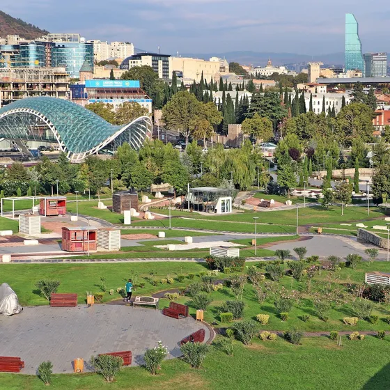 Aerial view of Tbilisi's Rike Park and the Bridge of Peace, with the Caucasus hills behind the city