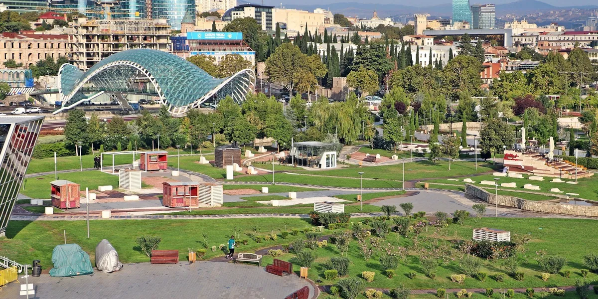 Aerial view of Tbilisi's Rike Park and the Bridge of Peace, with the Caucasus hills behind the city