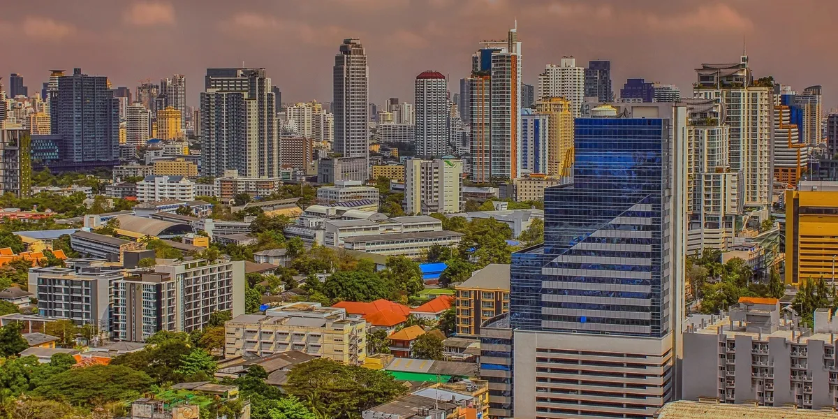 The Bangkok skyline of high-rises and glass towers under a dusky sky